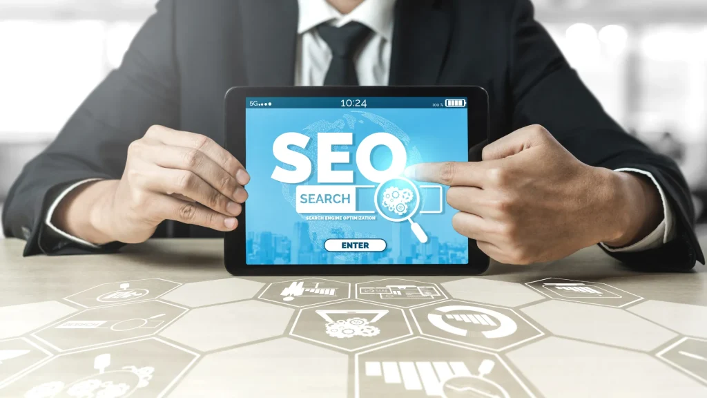 A person holding a tablet displaying an SEO search page with icons of SEO-related metrics.