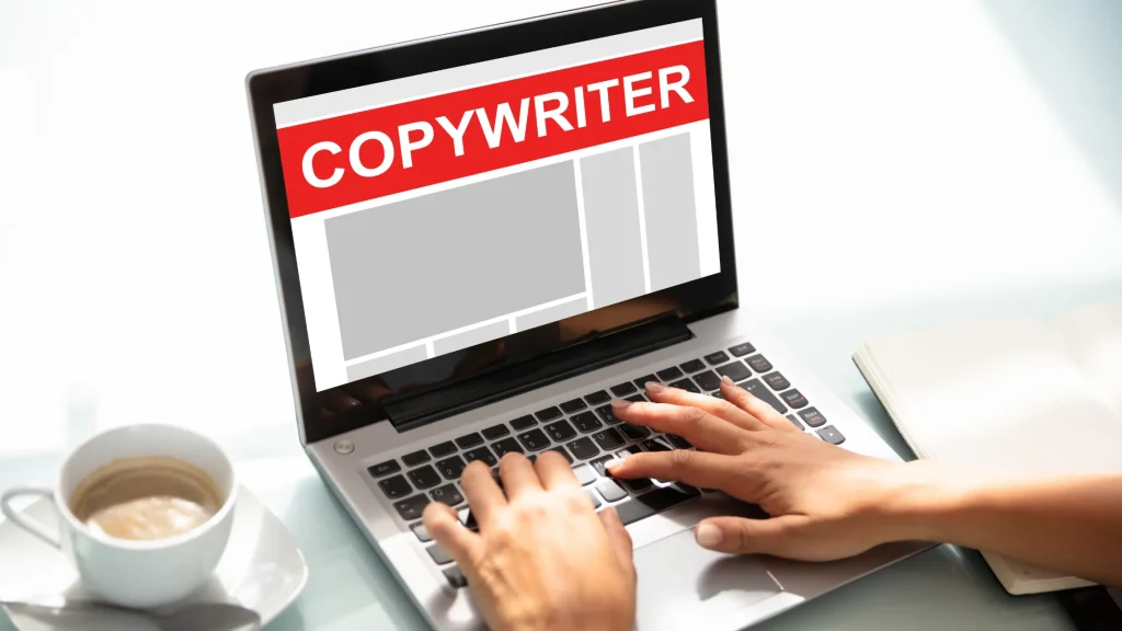 A person typing on a laptop displaying "COPYWRITER" with a cup of coffee beside them.