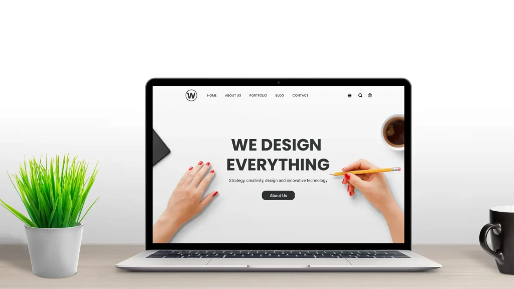 Laptop displaying a website with the "We Design Everything" message, offering affordable web development packages.